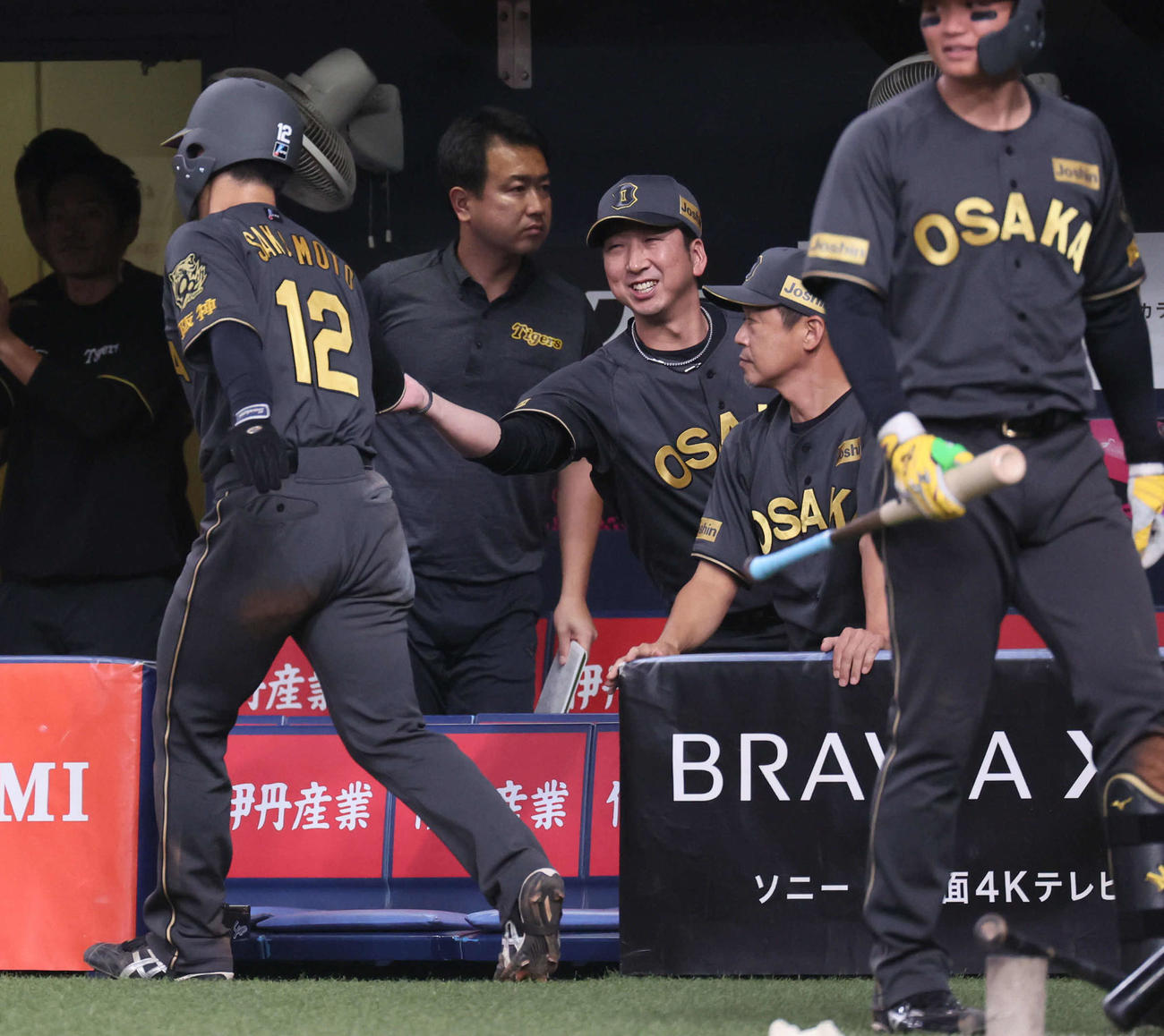 阪神対ヤクルト　8回裏阪神2死満塁、藤川監督（中央）は近本の3点適時三塁打で生還した坂本を笑顔で迎える（撮影・宮崎幸一)