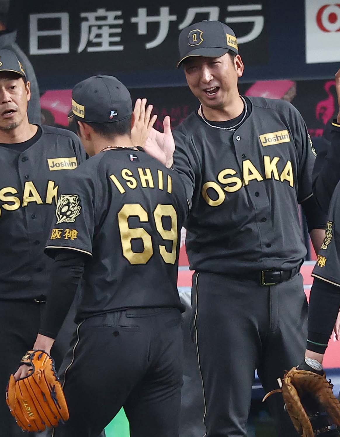阪神対ヤクルト　藤川球児監督（右）は自身のセリーグ記録の38試合連続無失点を達成した石井大智を笑顔で出迎える（撮影・上田博志）