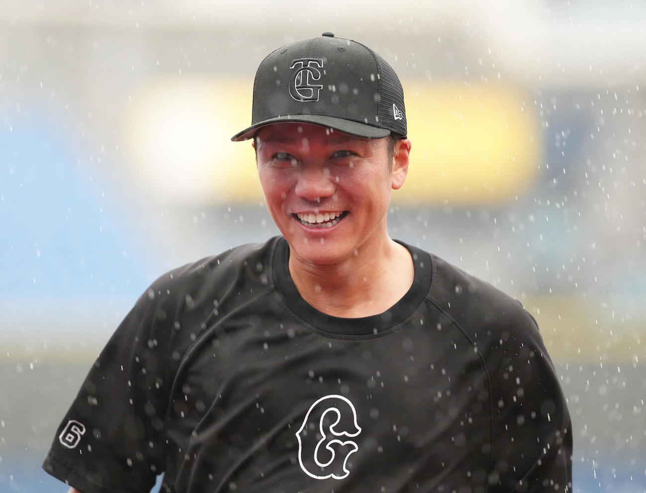 試合前、激しい雨にも笑顔を見せる巨人坂本（撮影・足立雅史）