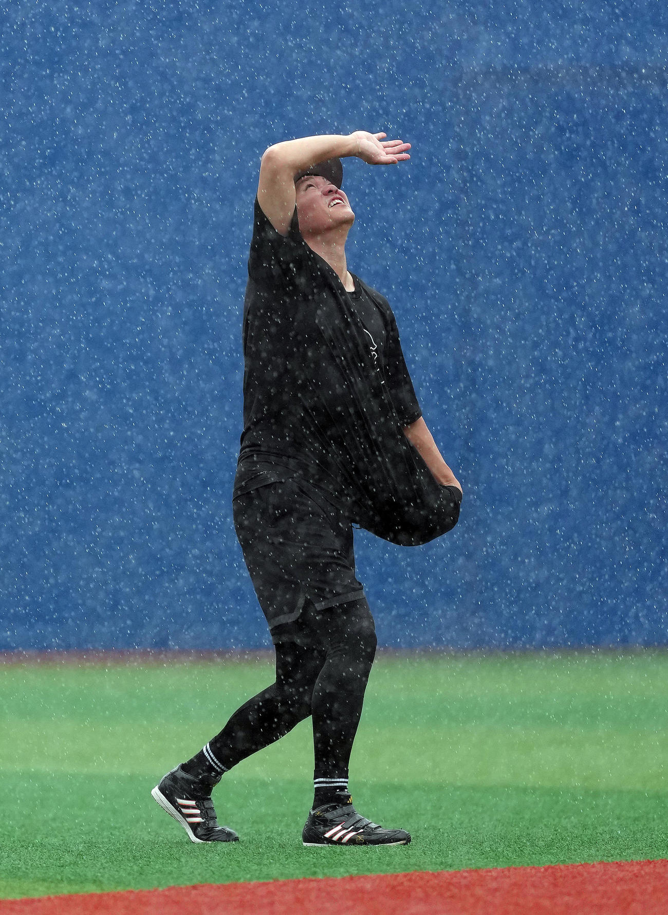 試合前、激しい雨の中、練習する巨人坂本（撮影・足立雅史）