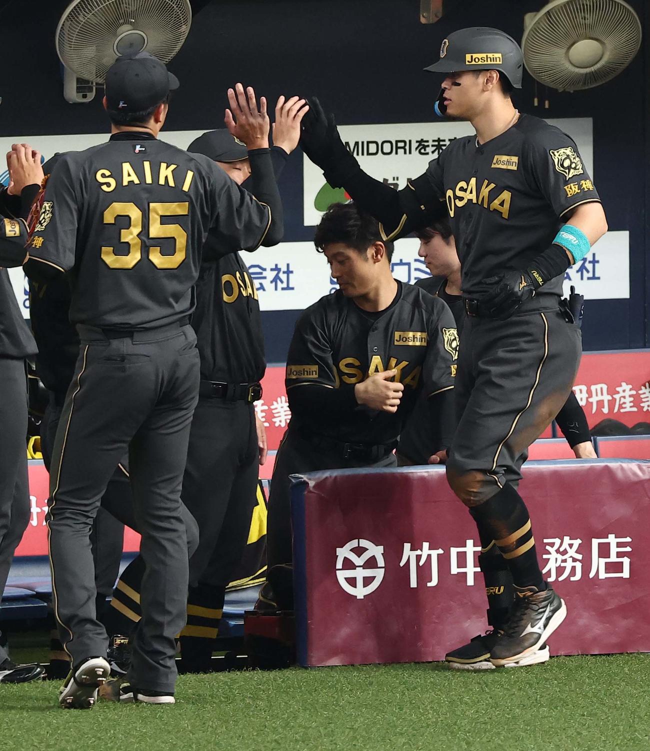 阪神対ヤクルト　3回裏阪神2死、ソロ本塁打を放った佐藤輝（右）は先発才木の出迎えを受ける（撮影・上田博志）