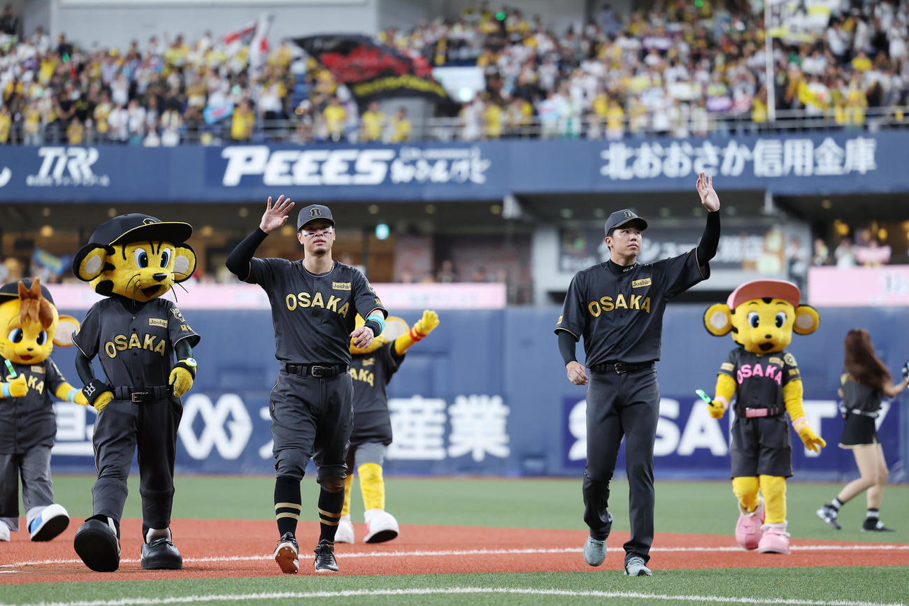 阪神対ヤクルト　ファンに手を振り引き揚げる阪神佐藤輝（左）と才木（撮影・前田充）
