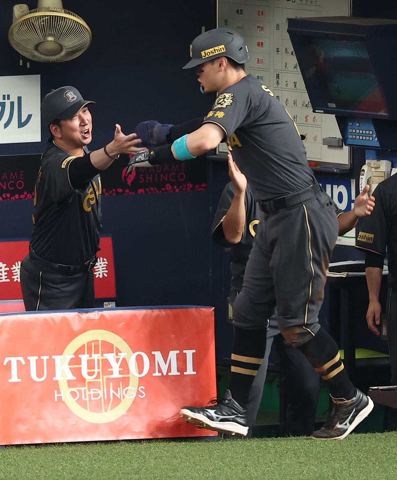 阪神対ヤクルト　5回裏阪神無死満塁、藤川監督（左）は坂本の適時打で生還した佐藤輝を出迎える（撮影・上田博志）