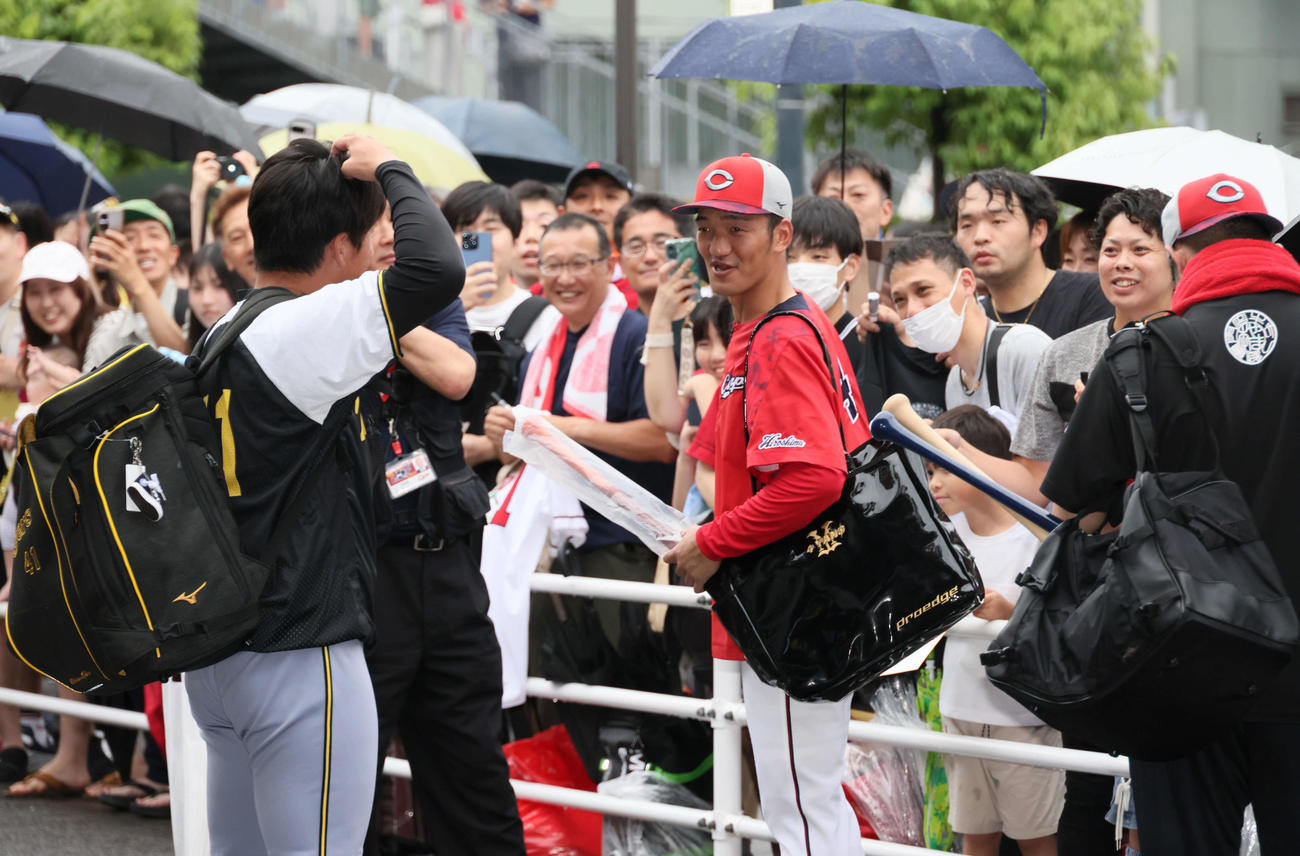 屋内練習場へ向かう阪神村上（左）に声をかける広島矢野（撮影・加藤孝規）