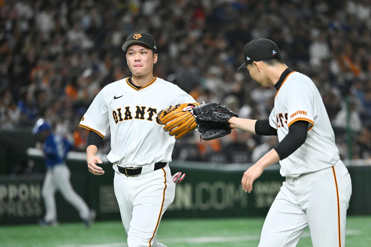 巨人対中日　4回表の守備を終えた三塁手坂本（左）は森田とタッチを交わす（撮影・滝沢徹郎）