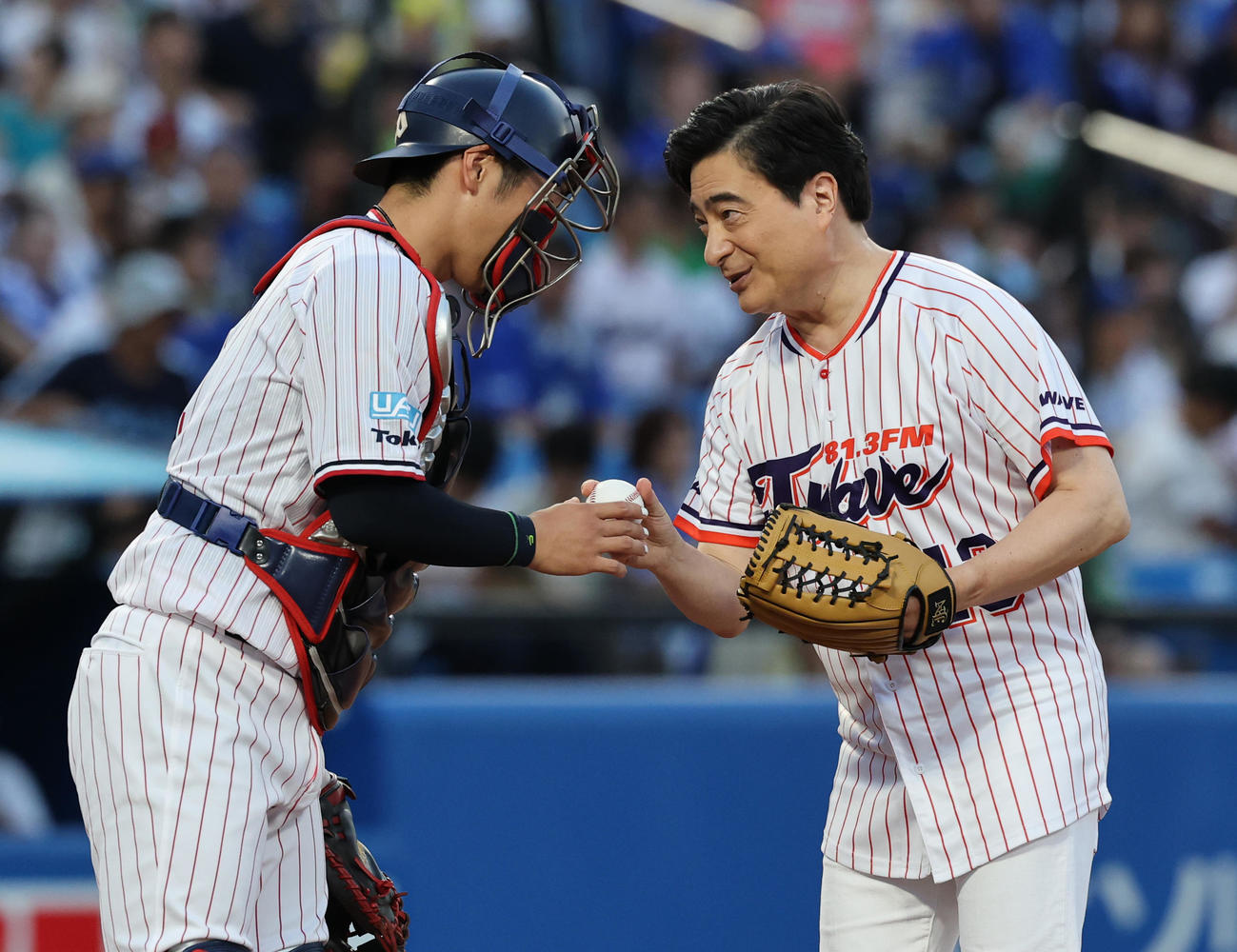 ヤクルト対DeNA　始球式を終え古賀（左）からボールをもらうジョン・カビラ（撮影・野上伸悟）