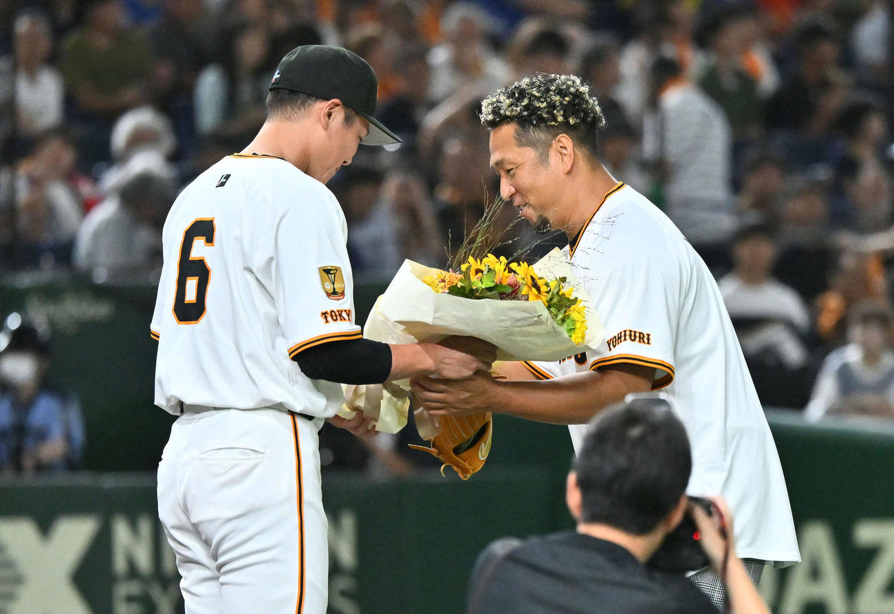 巨人対中日　試合前に行われた自身の引退セレモニーで中島氏（右）は巨人坂本から花束を受け取る（撮影・滝沢徹郎）
