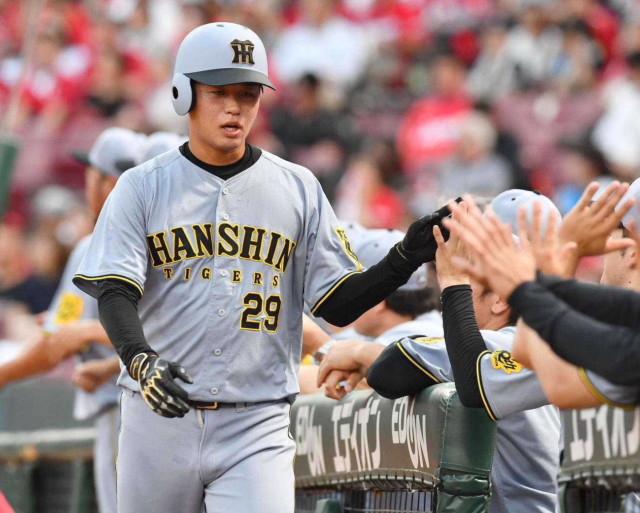 広島対阪神　3回表阪神無死二、三塁、中野の先制右犠飛で生還し、ナインとタッチを交わす高橋（撮影・岩下翔太）