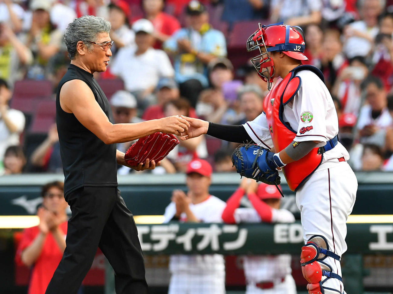 広島対阪神　始球式を終え、石原（右）から記念球を受け取る歌手の吉川晃司（撮影・岩下翔太）