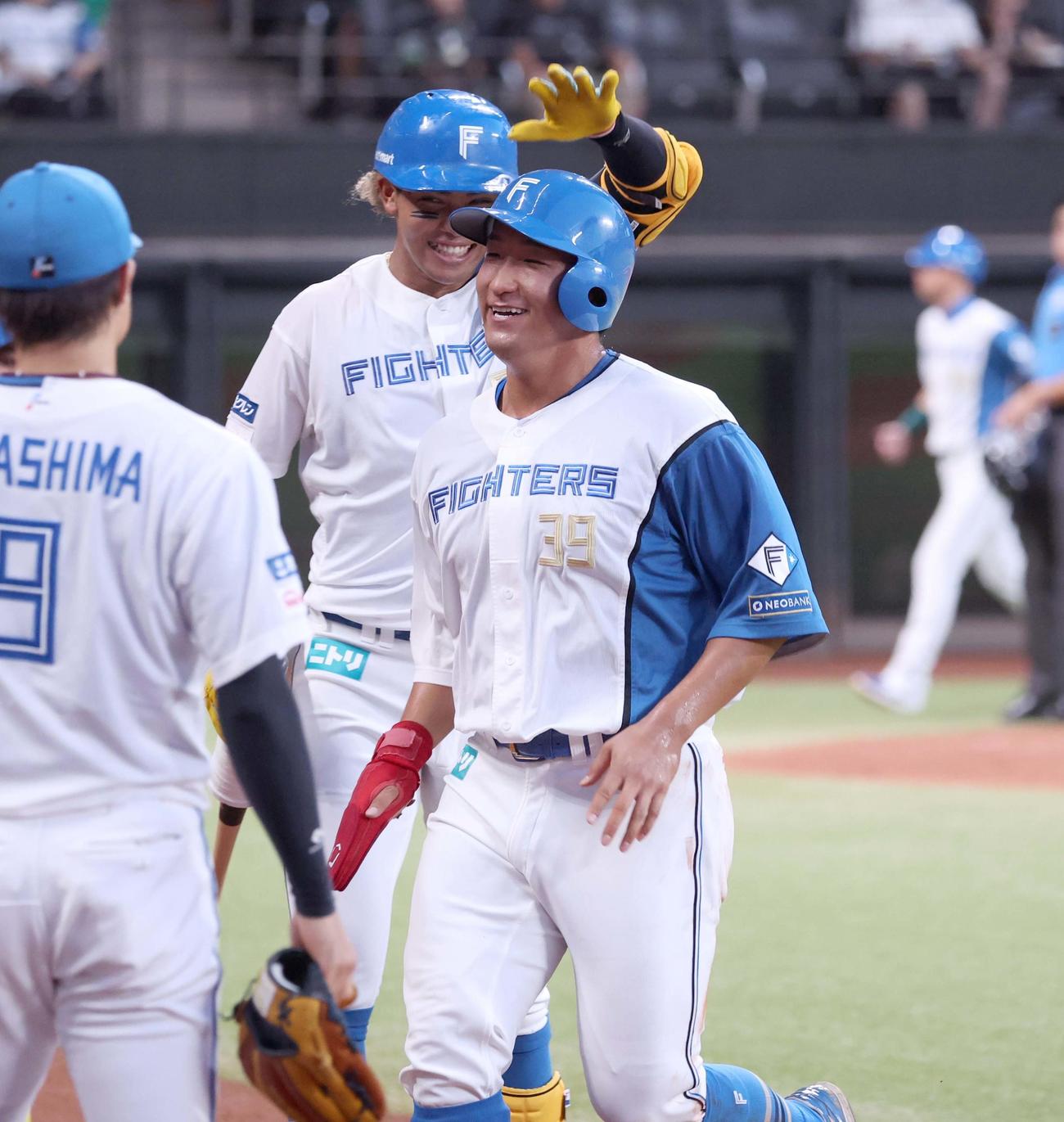 日本ハム対ロッテ　2回裏にプロ初安打を放ちナインに出迎えられ笑顔の有薗（撮影・黒川智章）