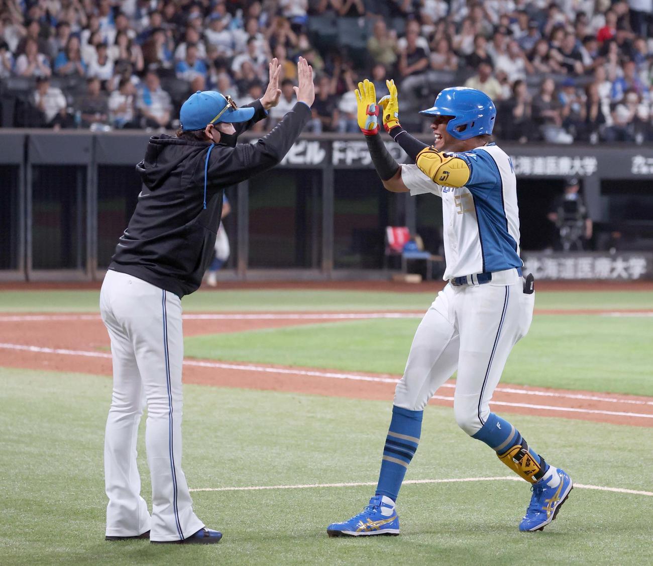 日本ハム対ロッテ　9回裏、サヨナラ打を放った水谷（右）を出迎える新庄監督（撮影・黒川智章）