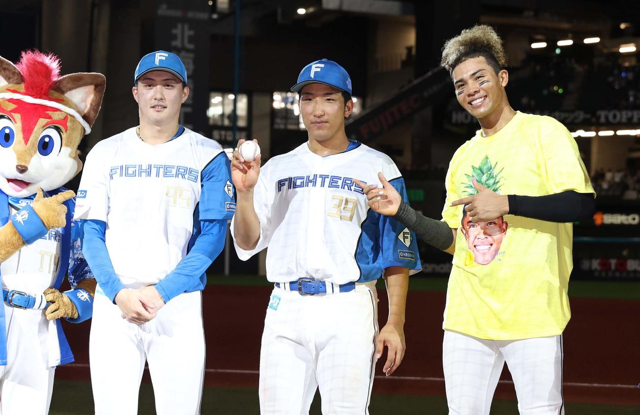 日本ハム対ロッテ　試合後、プロ初安打の記念球を掲げる有薗。左は柳川、右は水谷（撮影・黒川智章）