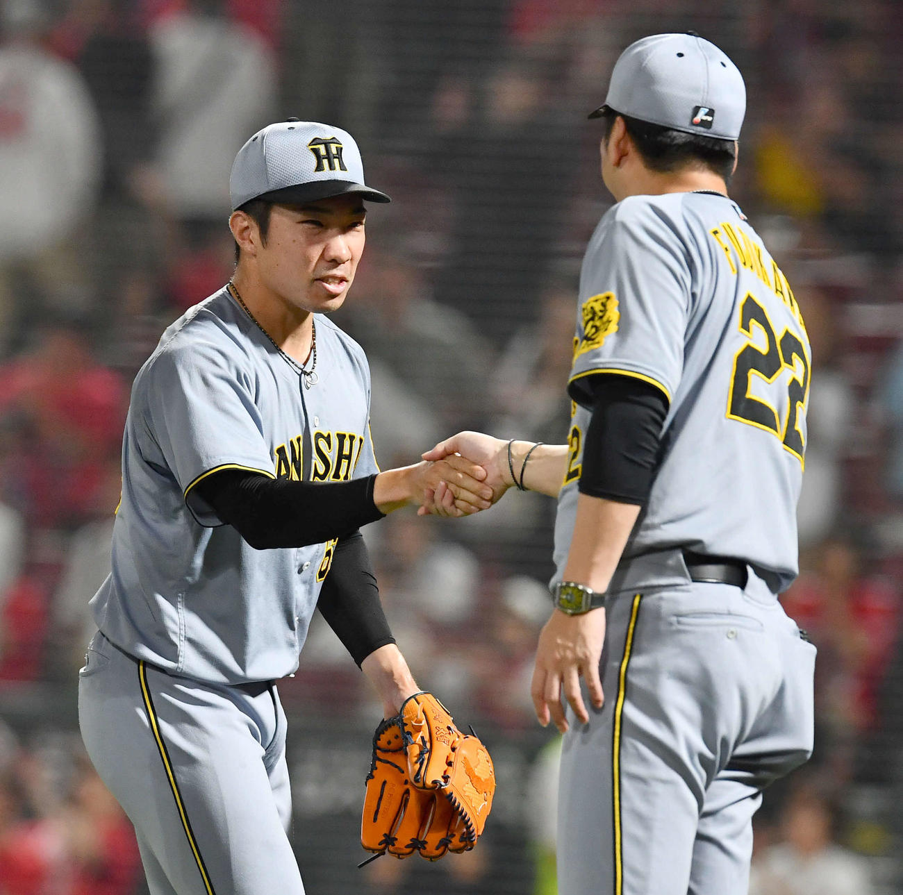 広島対阪神　セリーグ新記録となる39試合連続無失点を達成した石井（左）は藤川監督と握手を交わす（撮影・岩下翔太）