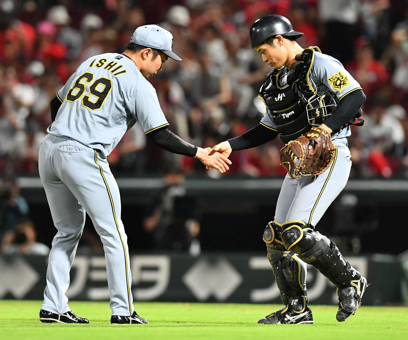 広島対阪神　セリーグ新記録となる39試合連続無失点を達成した石井（左）は坂本と握手を交わす（撮影・岩下翔太）