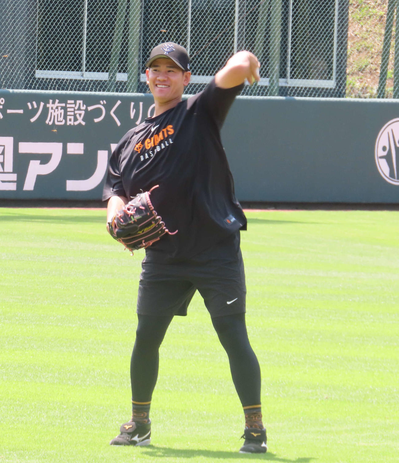 キャッチボール中に、笑顔を見せる巨人井上（撮影・水谷京裕）