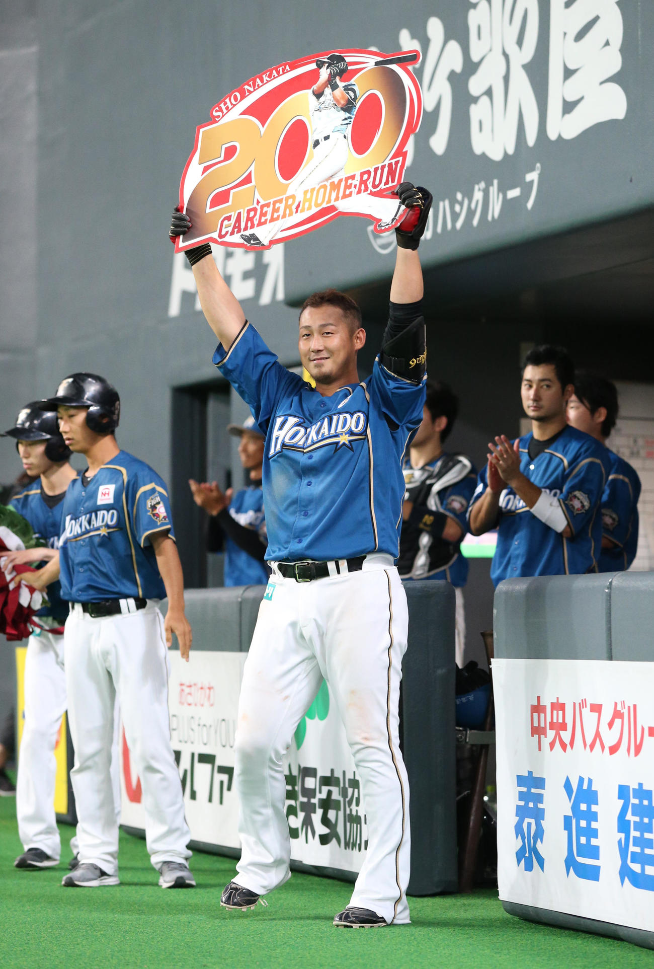 18年8月24日、通算200本塁打を達成し笑顔でスタンド応援席にパネルを掲げる中田翔
