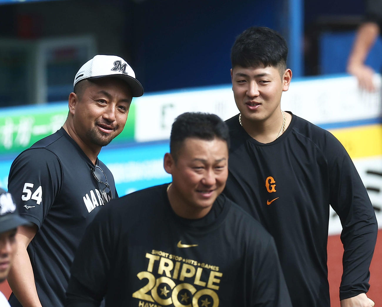 ロッテ対巨人　試合前、言葉を交わすロッテ沢村と巨人岡本和。手前は中田翔（撮影・河田真司）