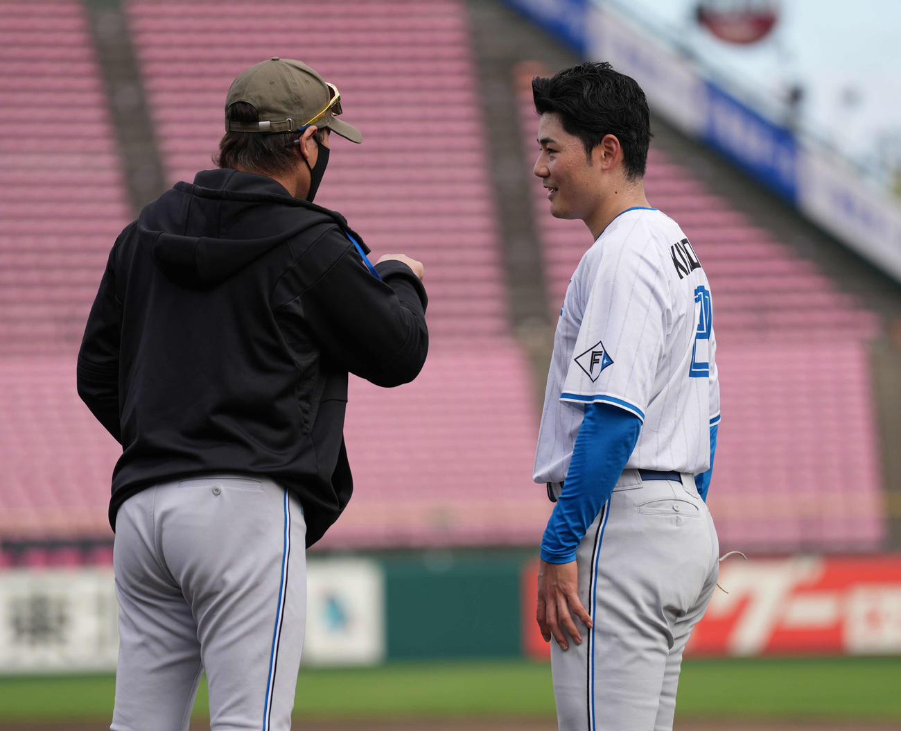 楽天対日本ハム　試合前練習で話す日本ハム清宮幸（右）と新庄監督（撮影・井上学）
