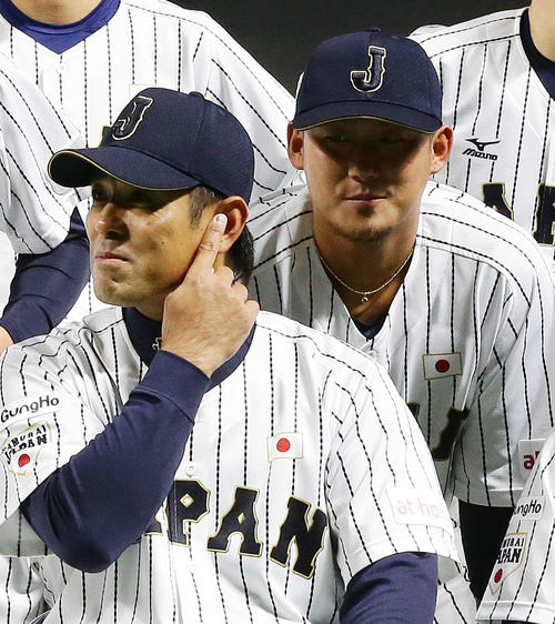 2015年11月4日　侍ジャパン集合写真撮影中、稲葉打撃コーチ（手前）の耳元に息を吹きかけイタズラした中田