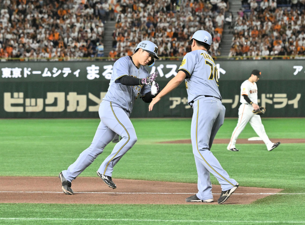 巨人対阪神　4回表阪神無死一塁、先制2点本塁打を放った大山（左）は田中コーチとタッチをかわす（撮影・滝沢徹郎）