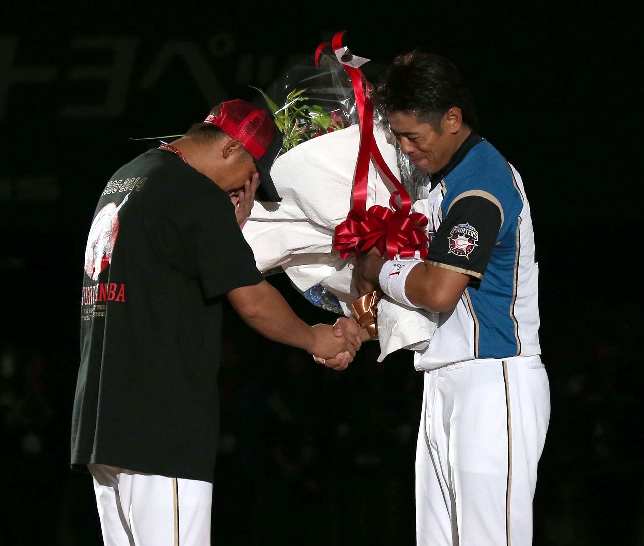 14年10月5日の引退セレモニーで中田から花束を受け取る稲葉篤紀