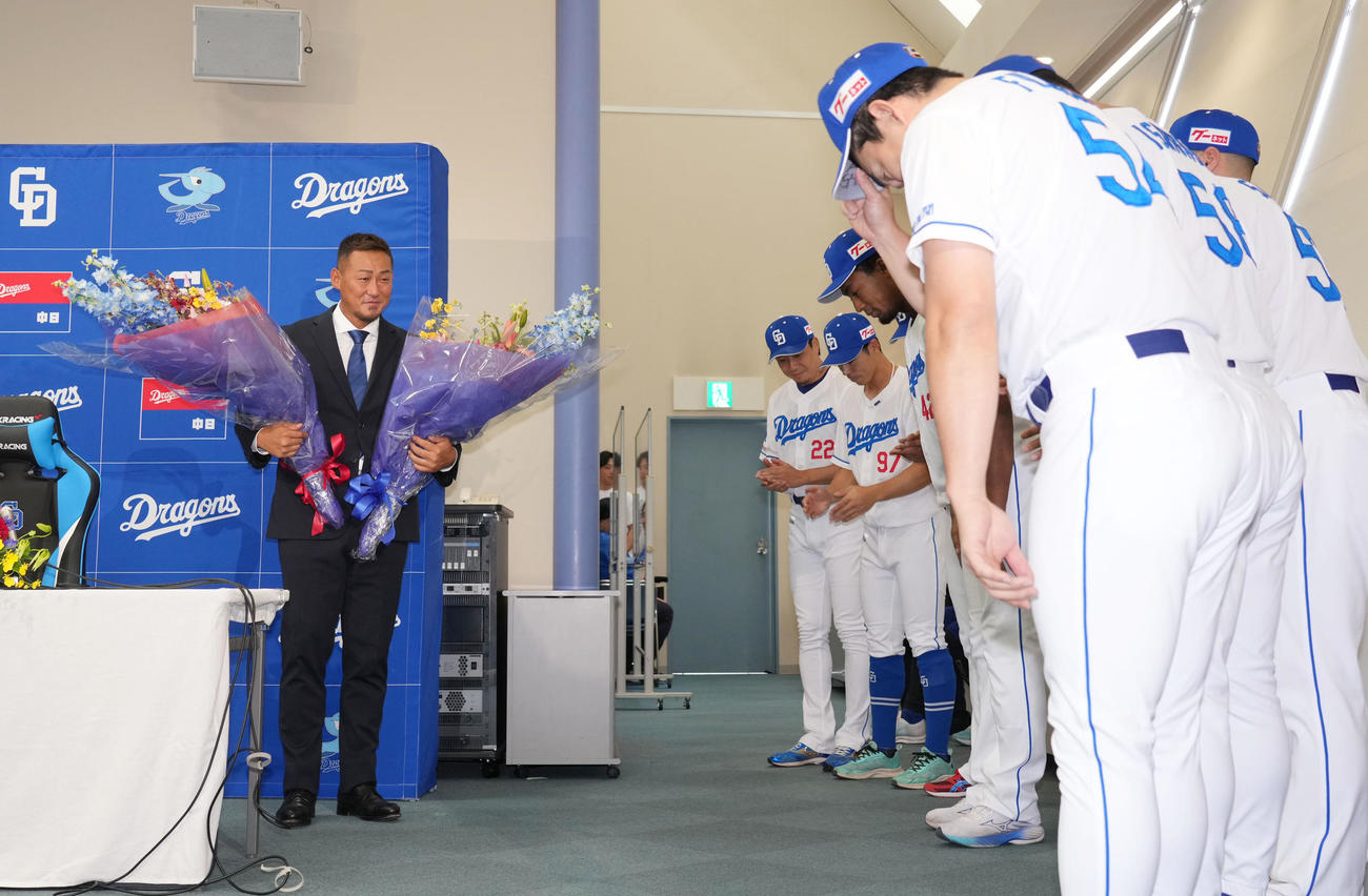 会見を終えた中日中田（左）はナインから花束を受け取り、一礼される（撮影・森本幸一）