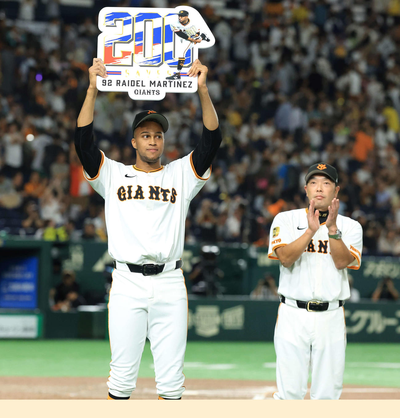巨人対阪神　9回表阪神の攻撃を抑え、通算200セーブしたマルティネスはボードを掲げる。右は阿部監督（撮影・浅見桂子）