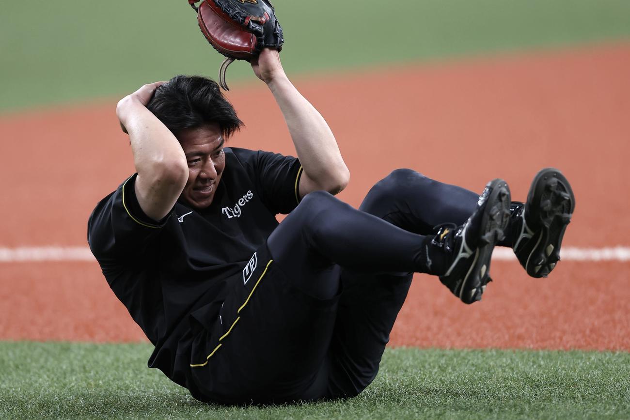 阪神対ヤクルト　試合前練習でボールが当たり、頭をおさえる阪神長坂（2025年8月9日撮影）