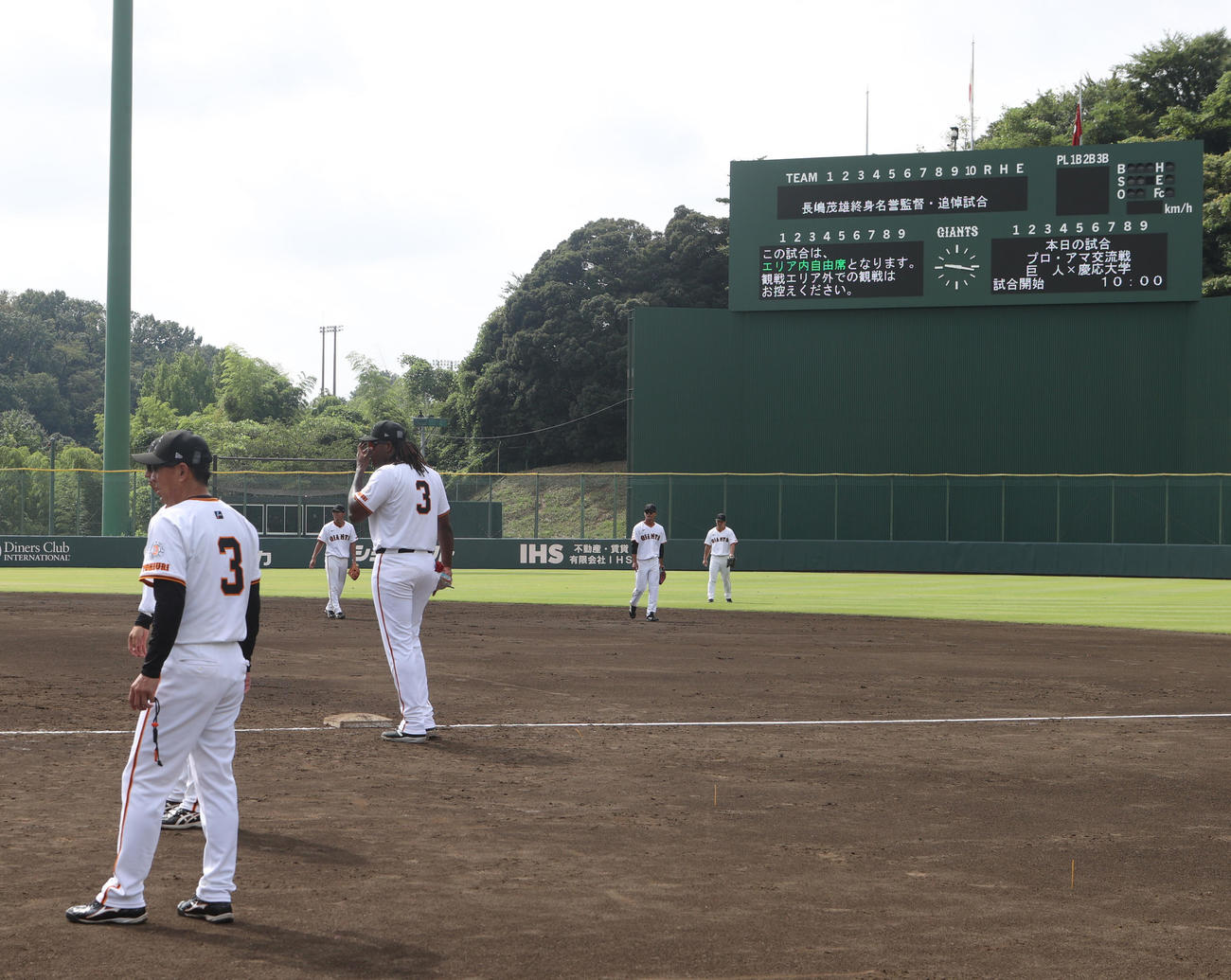 巨人3軍対慶大　長嶋茂雄巨人終身名誉監督の追悼試合前、スコアボードに半旗が掲げられた球場で練習する巨人ナイン（撮影・水谷安孝）