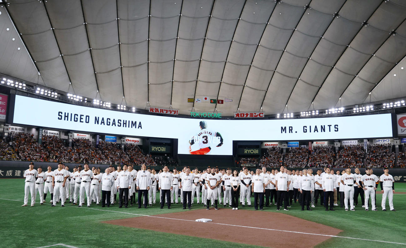 巨人対阪神　試合終了後、「3」の人文字を作り、頭上のドローンカメラに笑顔を向ける阿部監督（中央）らOB、選手たち