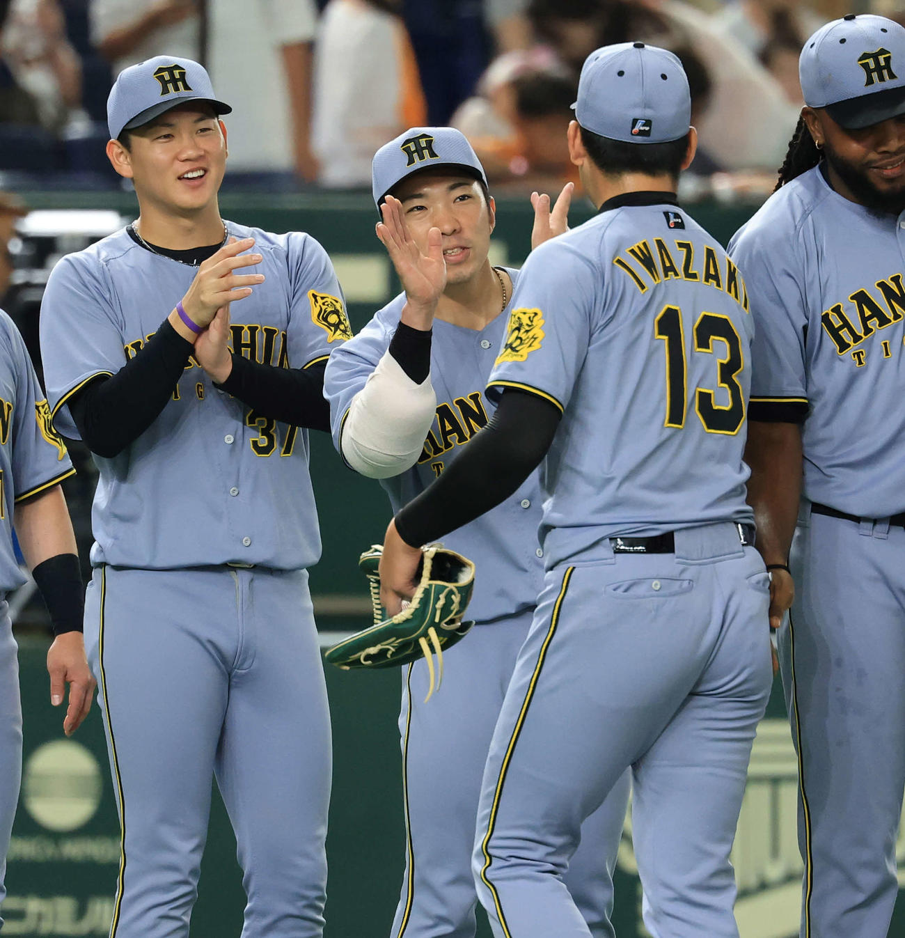 巨人対阪神　連勝し、40試合無失点記録となった石井（中央）は笑顔で岩﨑（手前）を迎える（撮影・浅見桂子）