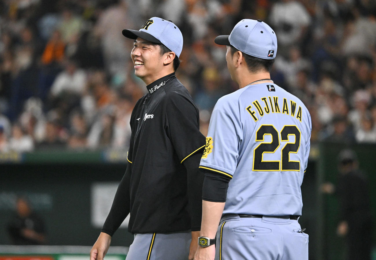 巨人対阪神　試合後、勝利投手の阪神才木（左）は藤川監督からねぎらわれ笑顔を見せる（撮影・滝沢徹郎）
