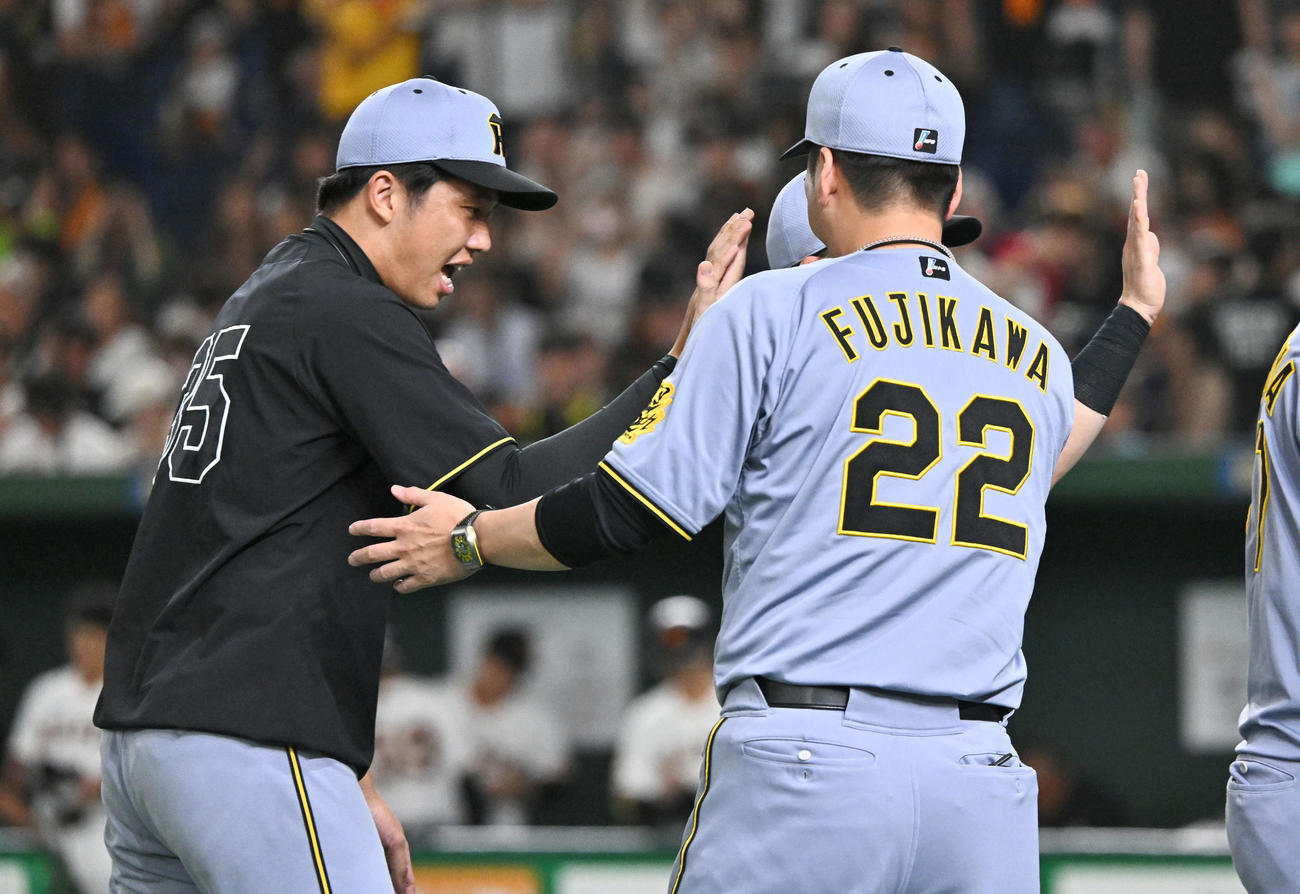 巨人対阪神　試合後、勝利投手の阪神才木（左）は藤川監督とタッチを交わす（撮影・滝沢徹郎）