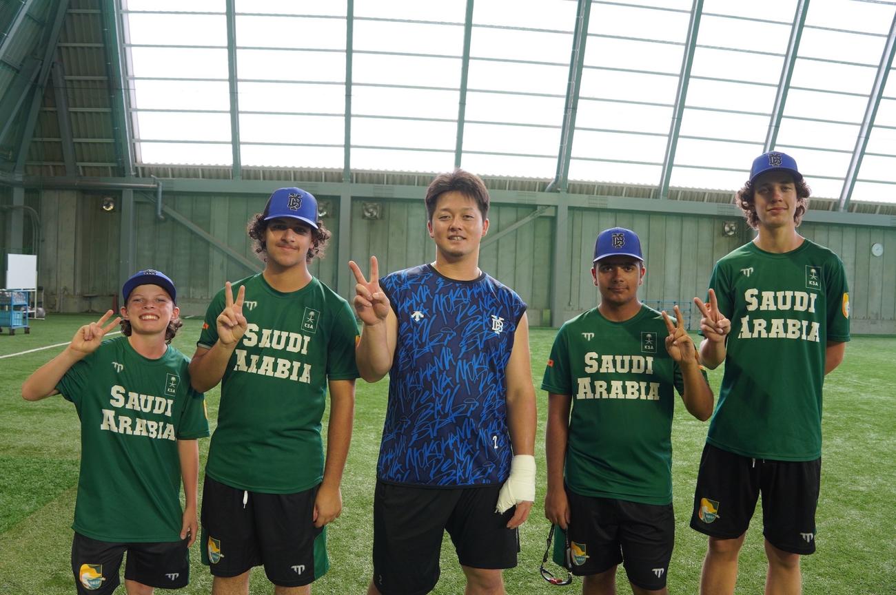 サウジアラビアの野球少年4人とギプス姿で写真に収まるDeNA牧（球団提供）