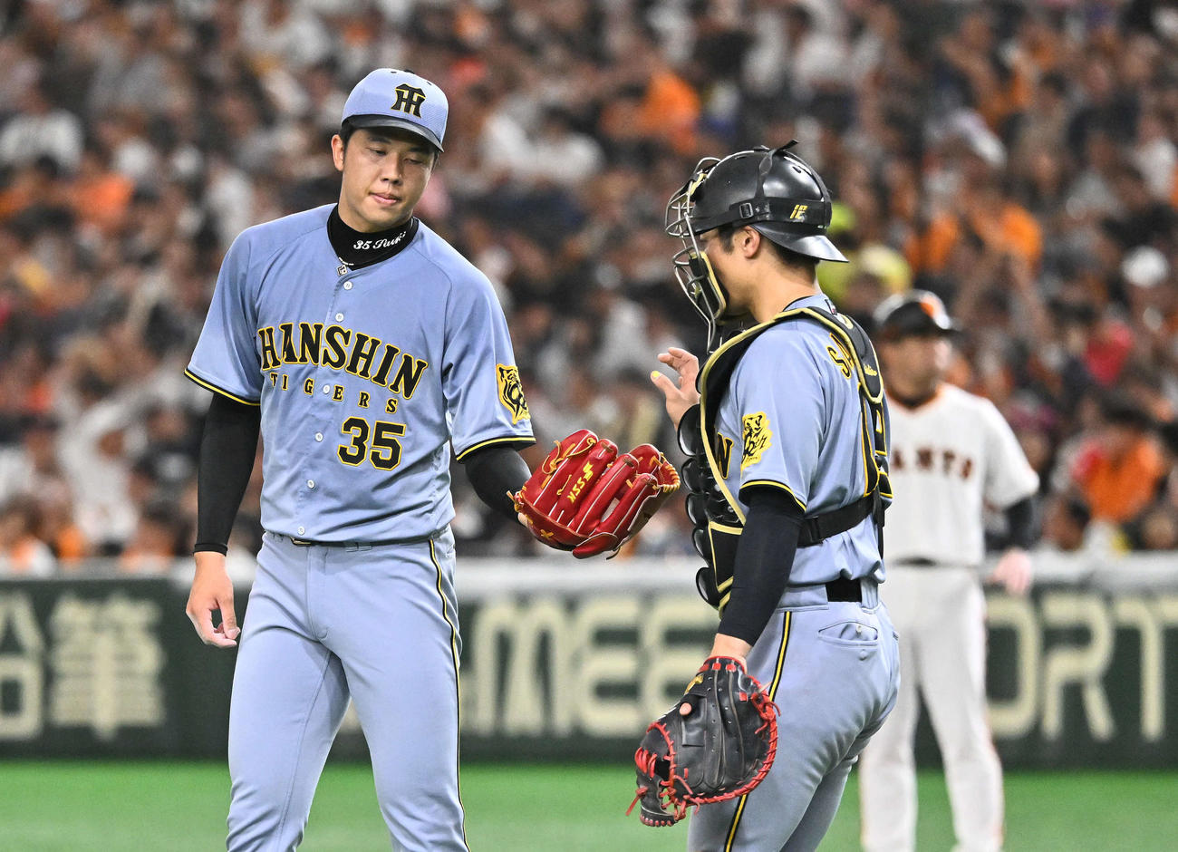 巨人対阪神　3回裏巨人1死一塁、泉口に四球を許した才木（左）は坂本からボールを受け取る（撮影・滝沢徹郎）