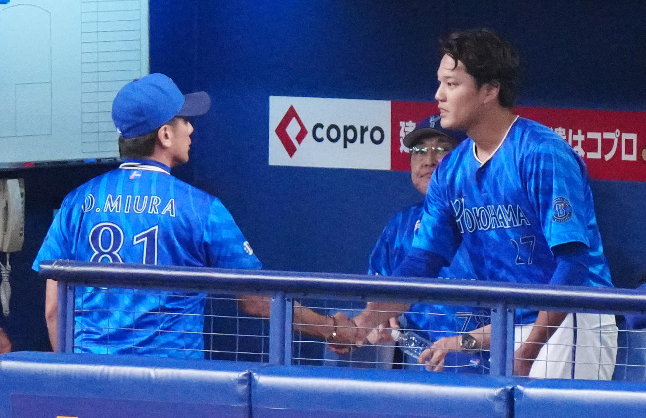 中日対DeNA 6回裏開始前、ベンチでDeNA三浦監督（左）と握手を交わす藤浪（撮影・江口和貴）