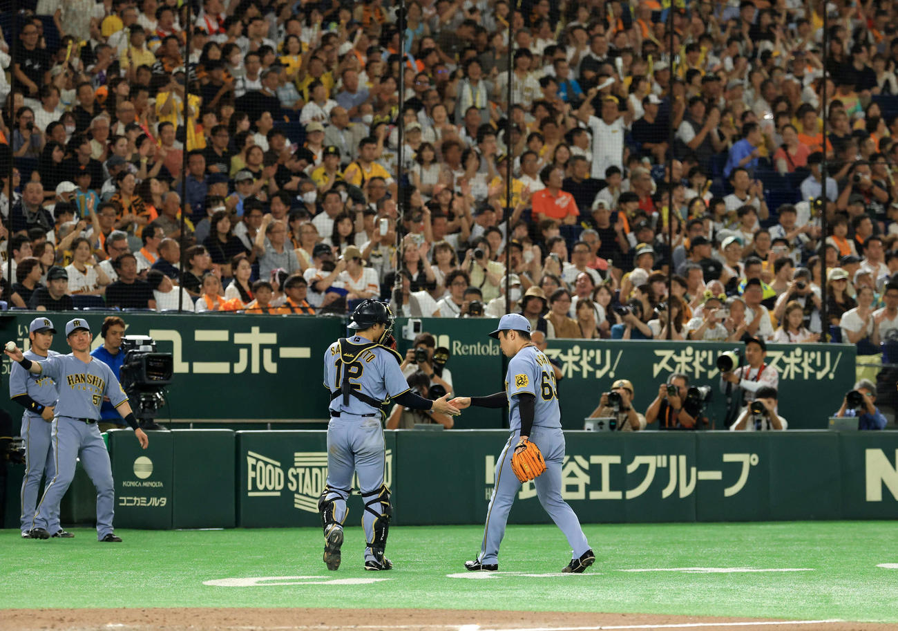 巨人対阪神　8回裏巨人の攻撃を抑え日本記録を更新した石井（右）は声援の中、坂本とハイタッチ（撮影・浅見桂子）