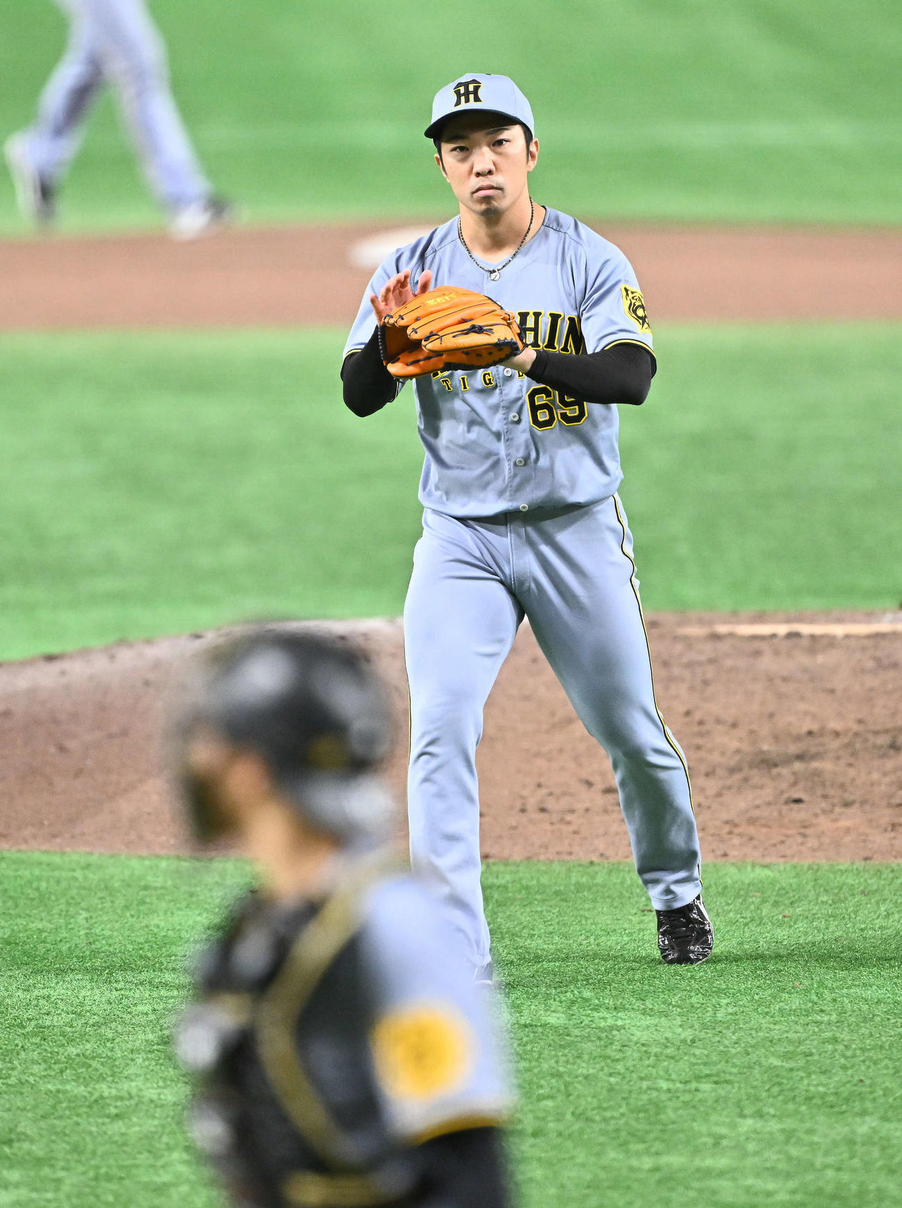 巨人対阪神　8回裏、40試合連続無失点を達成しグラブをたたく阪神石井（後方）（撮影・滝沢徹郎）