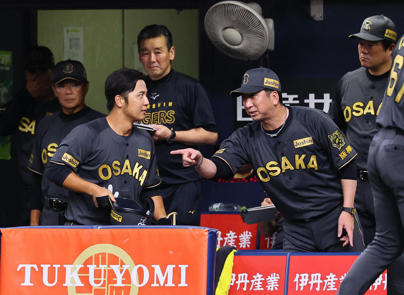 阪神対中日　2回裏阪神1死一、二塁、三塁内野安打を放つも挟殺プレーでアウトになり、ベンチで藤川監督（手前右）の話しを聞く井坪（撮影・藤尾明華）