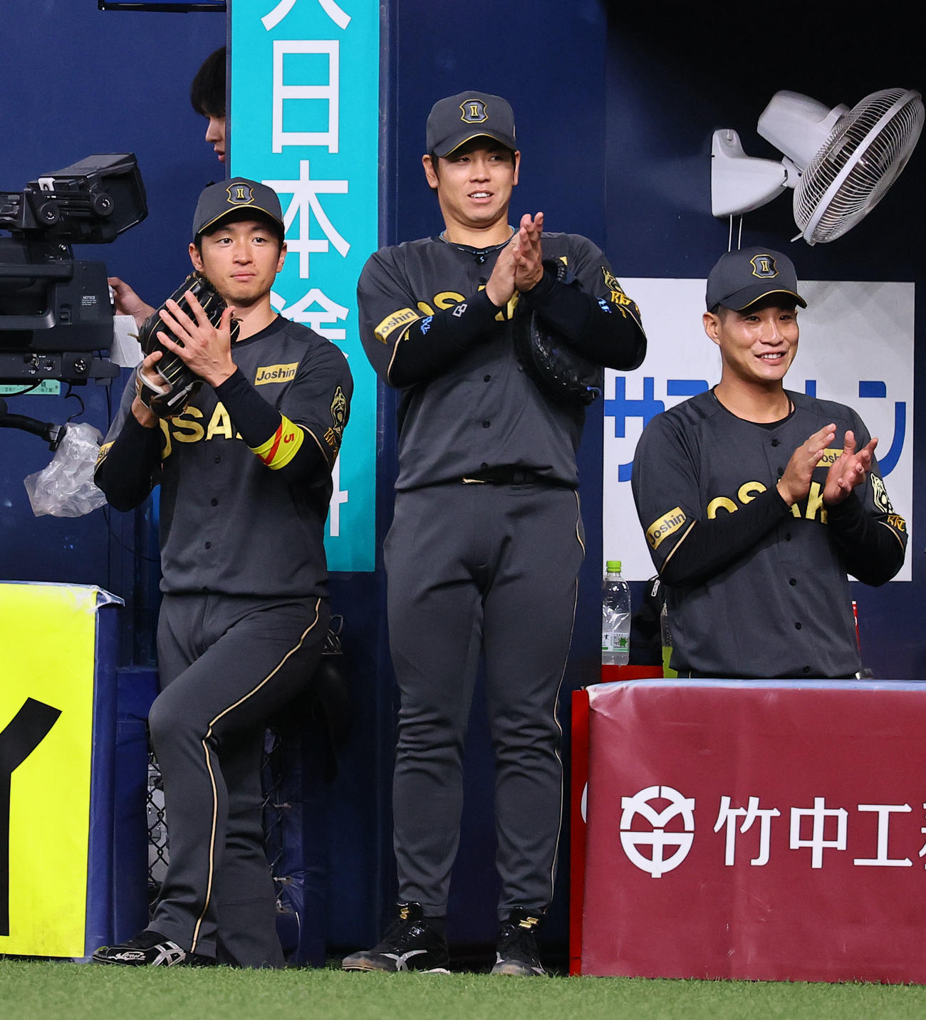 阪神対中日　始球式でベンチから拍手を送る阪神近本（左）、梅野（中央）、木浪（撮影・藤尾明華）