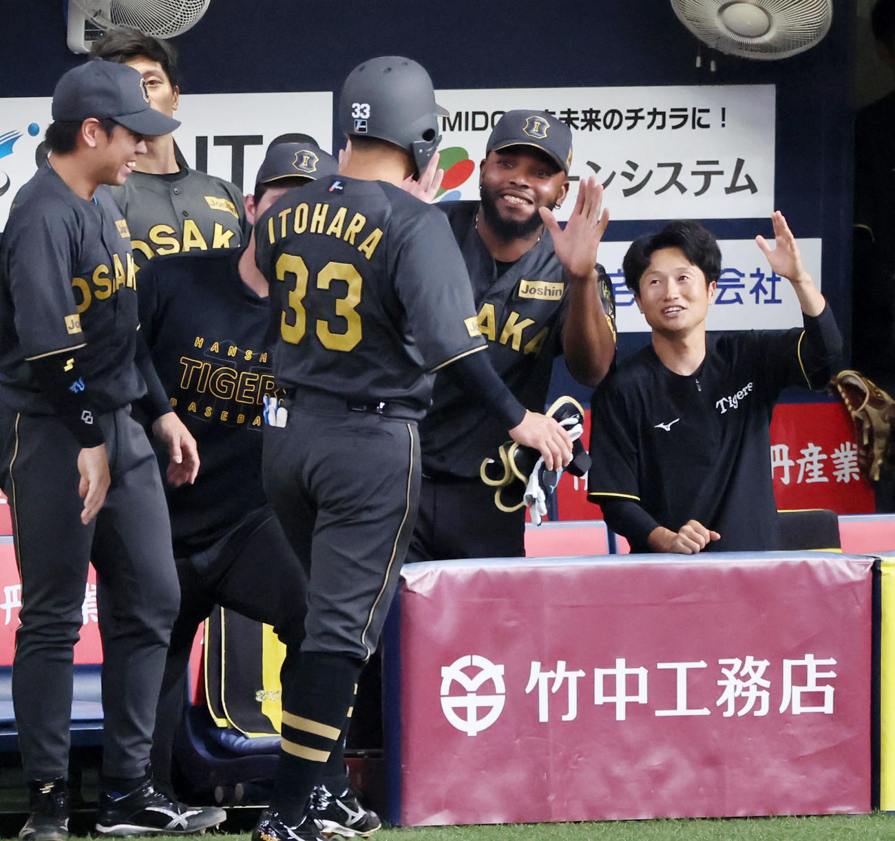 阪神対中日　6回裏阪神2死一、三塁、ベンチのドリスは右前適時打を放った代打糸原（左）を笑顔で出迎える（撮影・加藤哉）