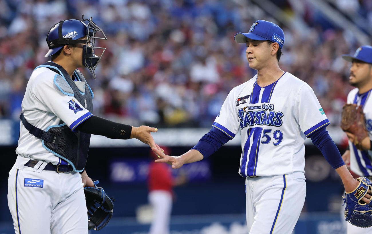 DeNA対広島　1回表を終え山本（左）とタッチするDeNA先発の平良（撮影・野上伸悟）