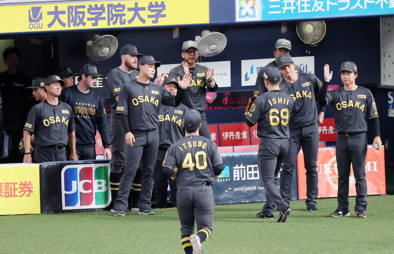 阪神対中日　8回表を無失点ピッチングで締めベンチへ引き揚げる石井を拍手で迎える藤川球監督らナイン（撮影・加藤哉）