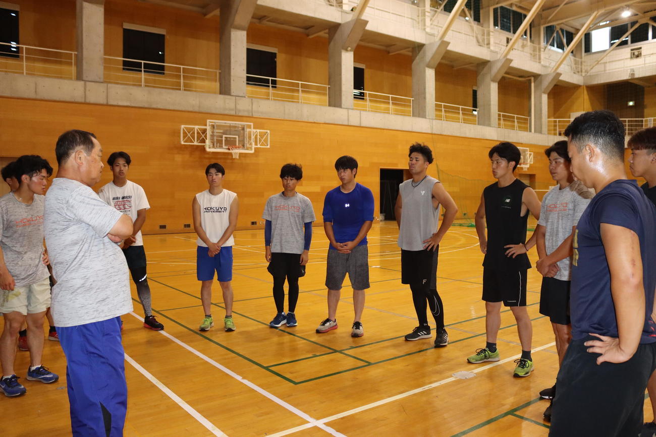 大滝監督（手前左端）の話を聞く北洋大の選手ら（撮影・保坂果那）