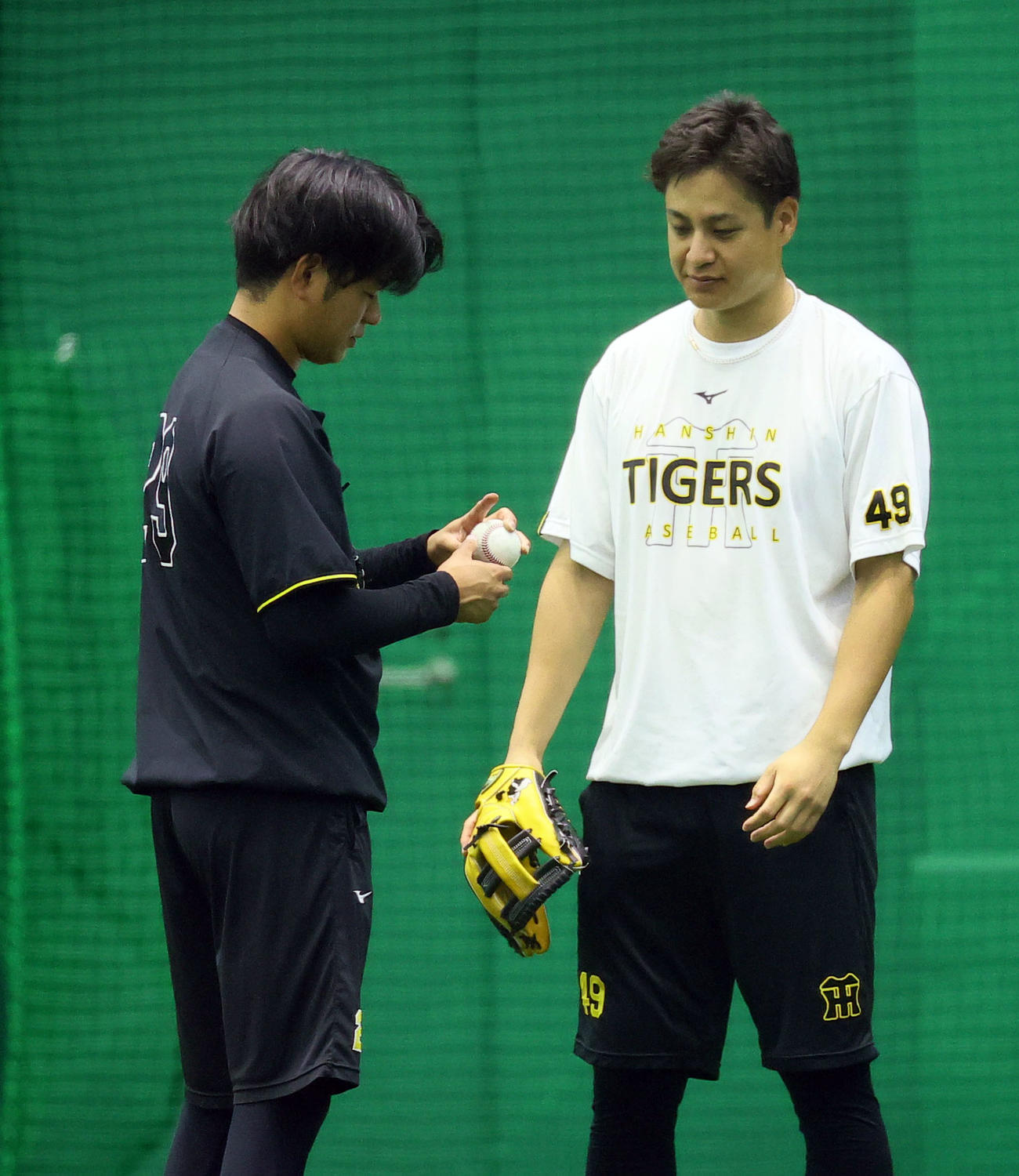 SGLで高橋遥人（左）に変化球の握りを教える大竹