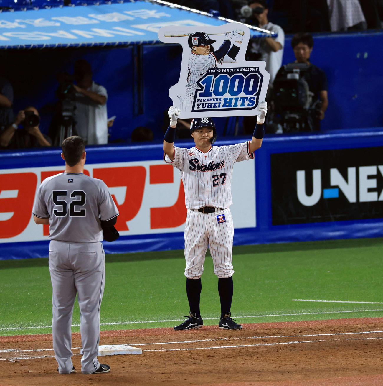 ヤクルト対巨人　3回裏ヤクルト無死、中村悠は左前打を放って1000安打としボードを掲げる（撮影・浅見桂子）