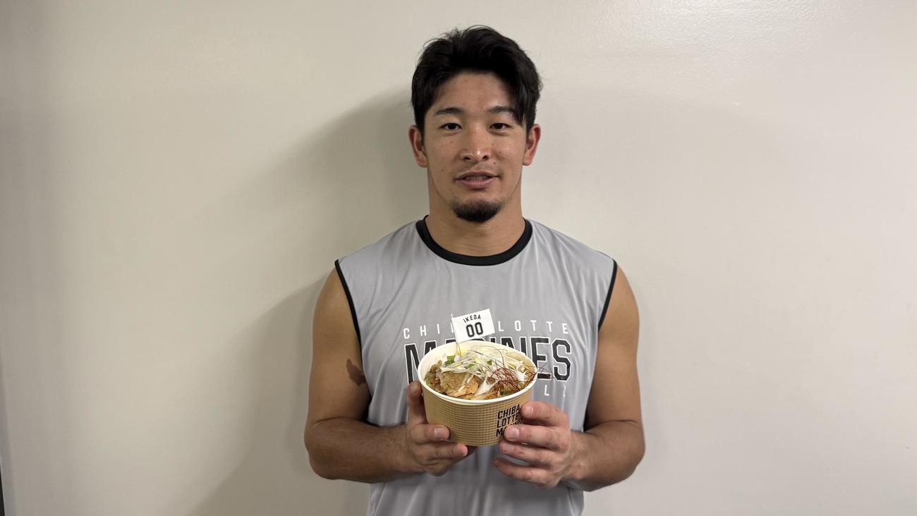 「池田のねぎ塩観音池ポーク丼」を持つ池田（球団提供）
