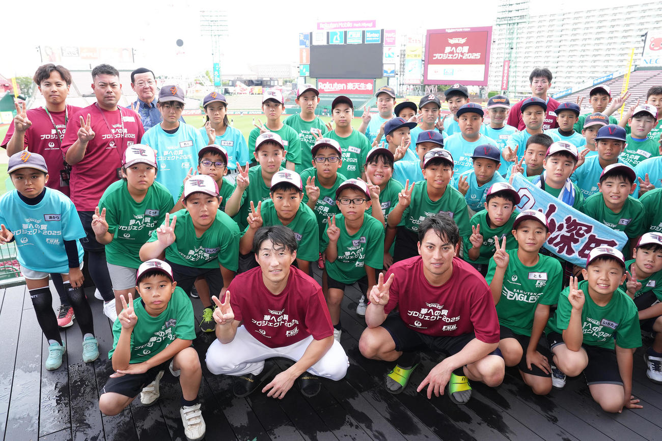 試合前、東北、沖縄・金武町の子どもたちと交流し、記念撮影する楽天の小深田（手前中央左）と小郷（同右）（撮影・足立雅史）