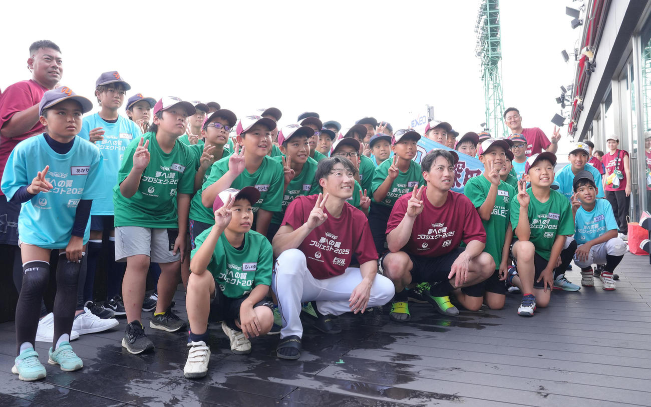 試合前、東北、沖縄・金武町の子どもたちと交流し、記念撮影する楽天の小深田（手前中央左）と小郷（同右）（撮影・足立雅史）