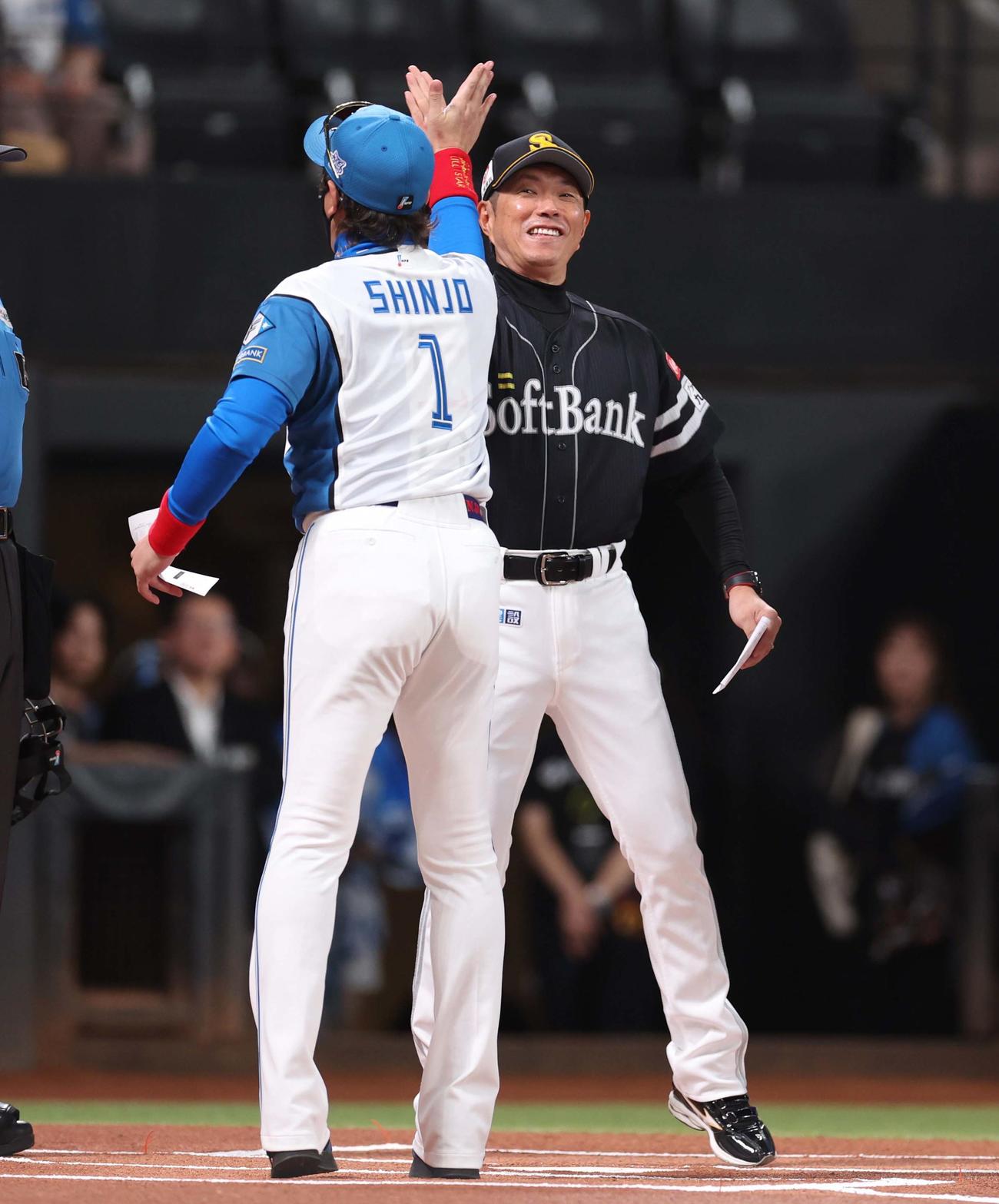 日本ハム対ソフトバンク　メンバー表交換で小久保監督とハイタッチする新庄監督（撮影・黒川智章）